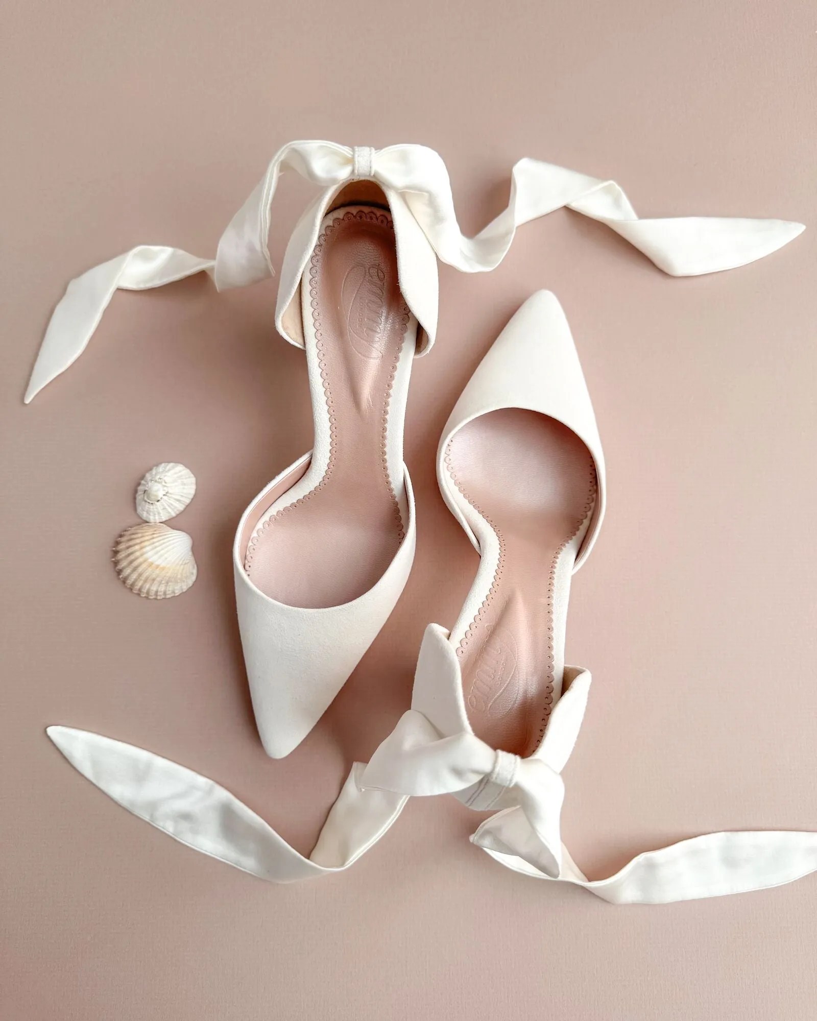 Ivory pointed-toe bridal heels with satin ribbon ankle ties